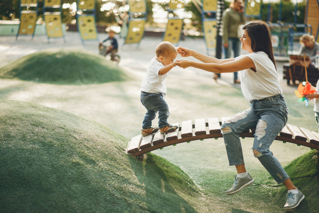 giwa-mamma-che-fa-camminare-bambino-piccolo-su-ponticello-in-legno